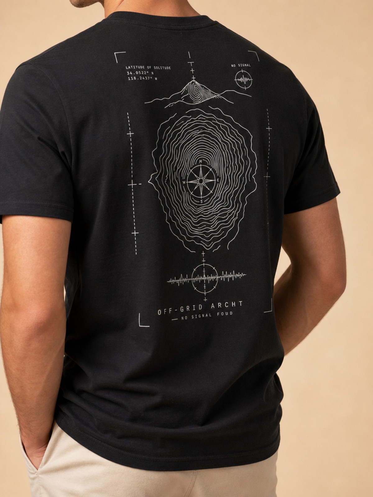 A man wearing a black t-shirt with a white technical blueprint-style graphic on the back, featuring a signal tower, compass, and soundwave design. The shirt has the text 'OFF-GRID ARCHY' and 'NO SIGNAL FOUND' printed on it.