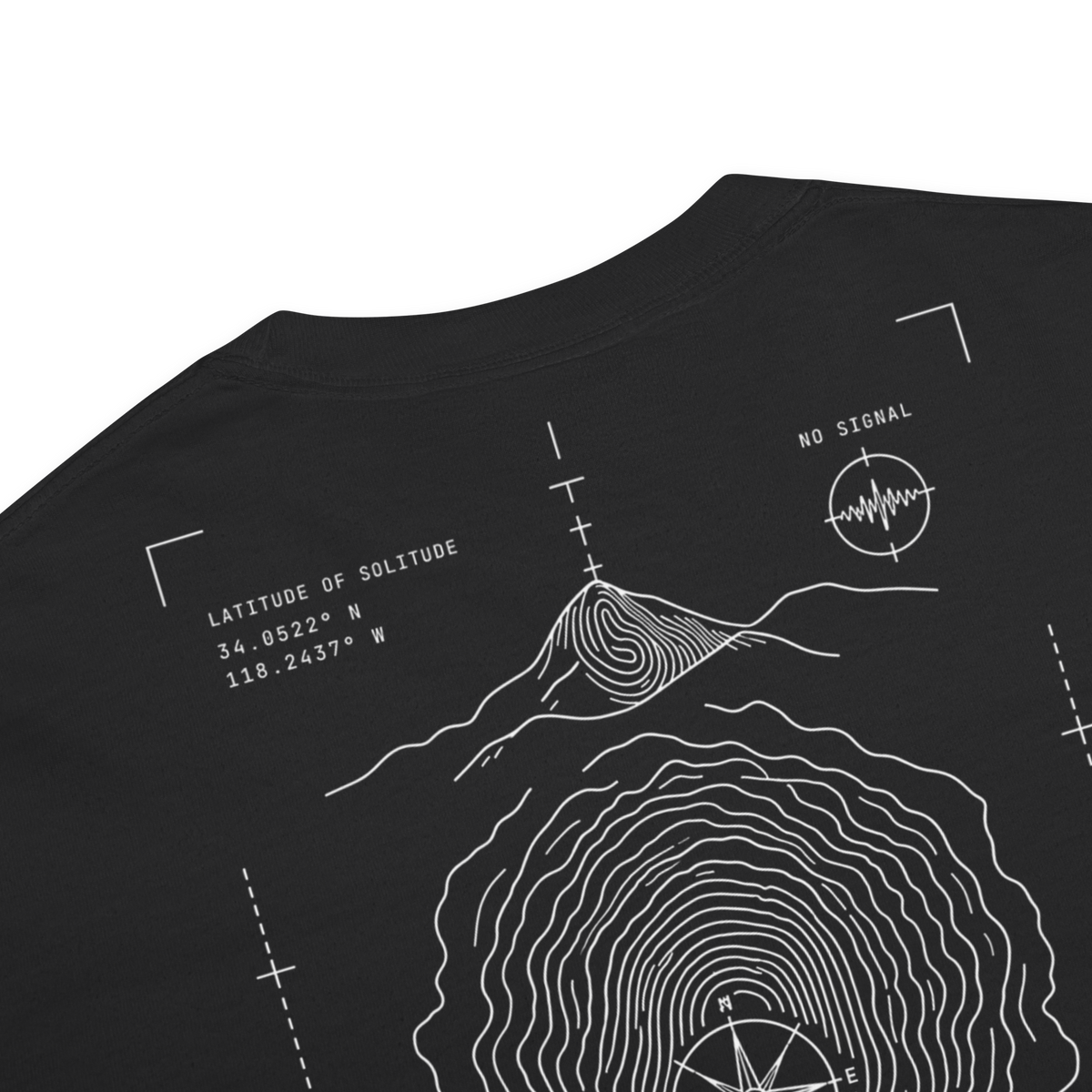 Close-up of a black t-shirt showing a white line-art graphic of a mountain topographic map with coordinates and a signal wave circle.