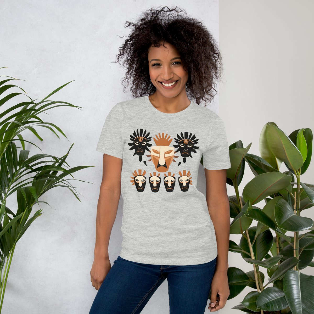 Front view of an athletic heather grey streetwear t-shirt featuring a striking geometric tribal mask graphic in terracotta, cream, and black.