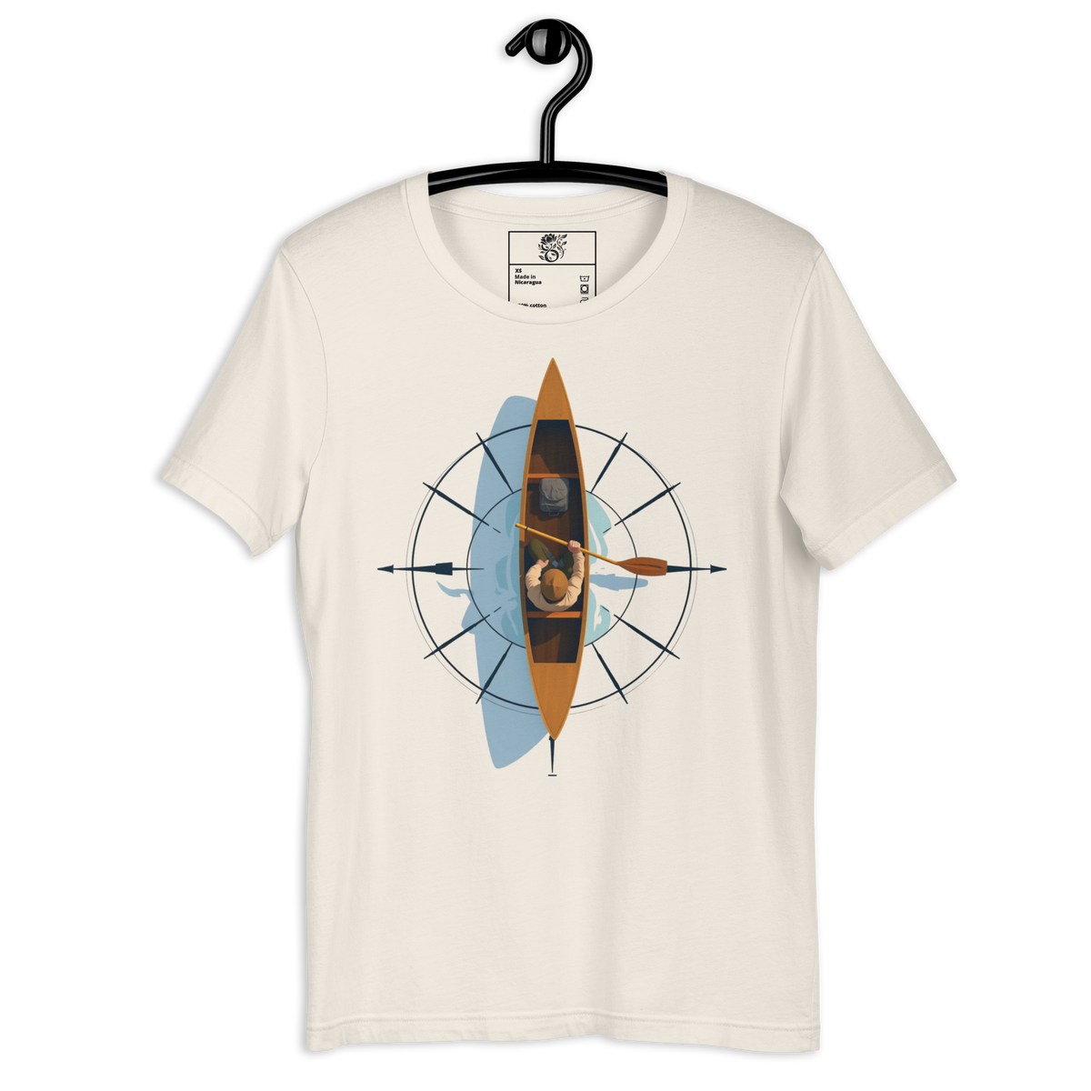 An off-white crewneck t-shirt on a black hanger, featuring a central graphic of a person kayaking inside an orange kayak, surrounded by a blue watercolor splash and a black compass design.