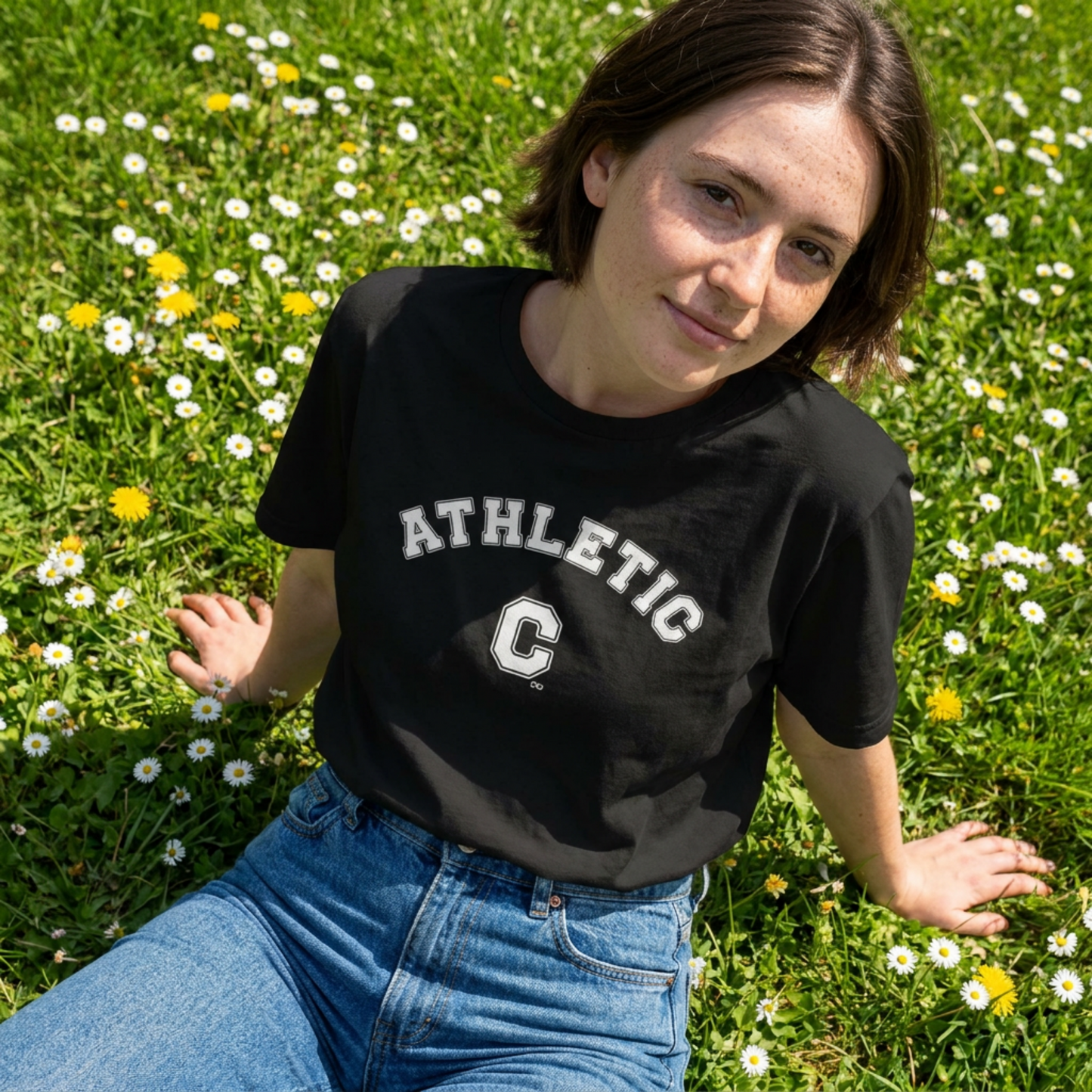 Front view of a black unisex eco-friendly t-shirt featuring a white vintage varsity-style 'Athletic C' graphic design.